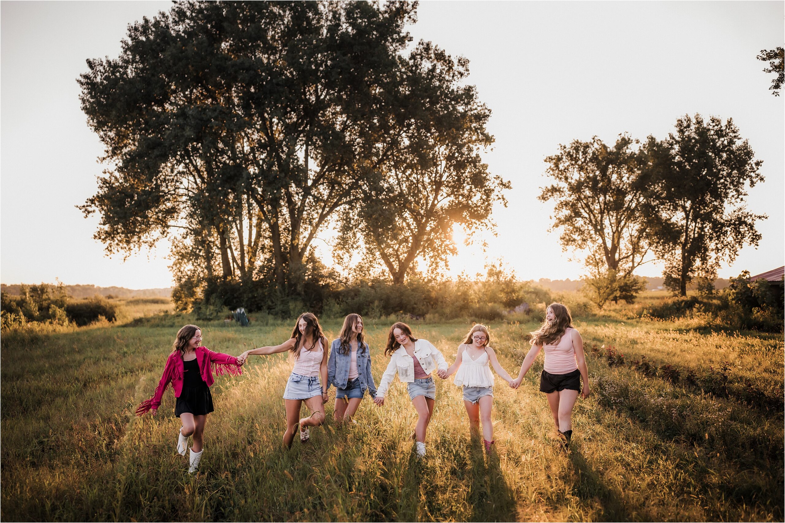 Group of friends walking through wildflowers in Dolly Parton inspired outfits